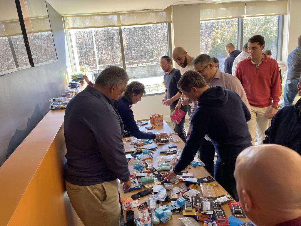 Team members enthusiastically sorting items to create care packages for military personnel during the Operation Military Care event.