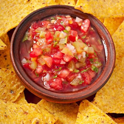 A vibrant bowl of fresh salsa surrounded by crispy tortilla chips, showcasing the flavors created during the Salsa Showdown team building event.