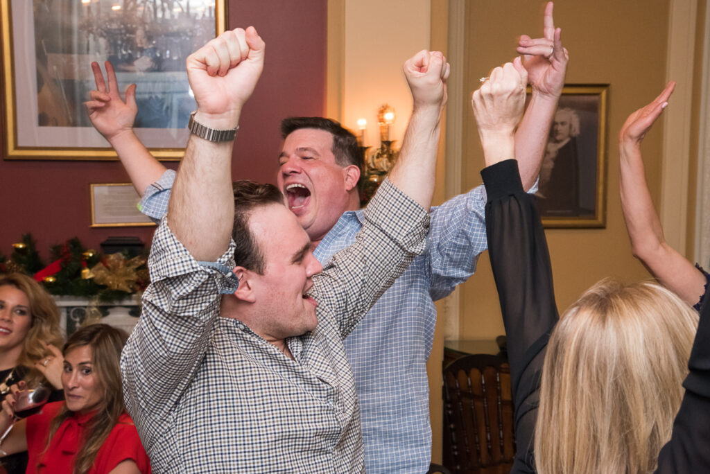Team members cheer enthusiastically after a victory during the Wild Card Team Building Bingo event, fostering excitement and camaraderie.