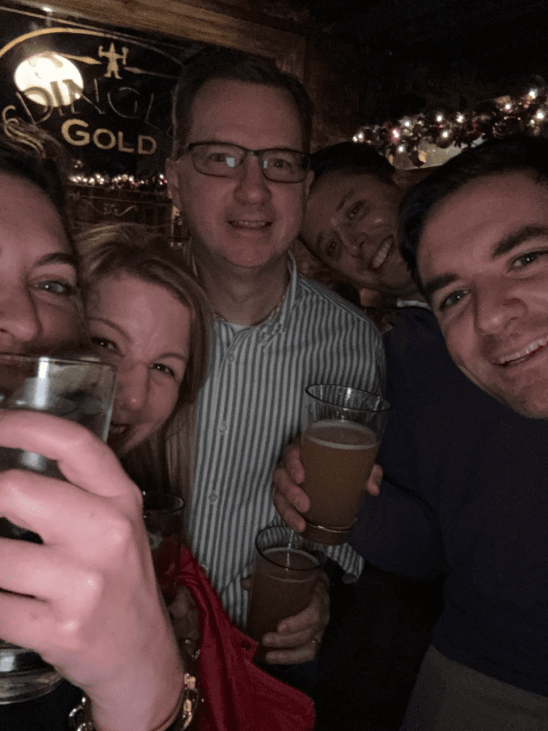 Team members share a cheerful moment with drinks in hand during the Pub Crawl Scavenger Hunt, creating lasting memories of camaraderie and fun.