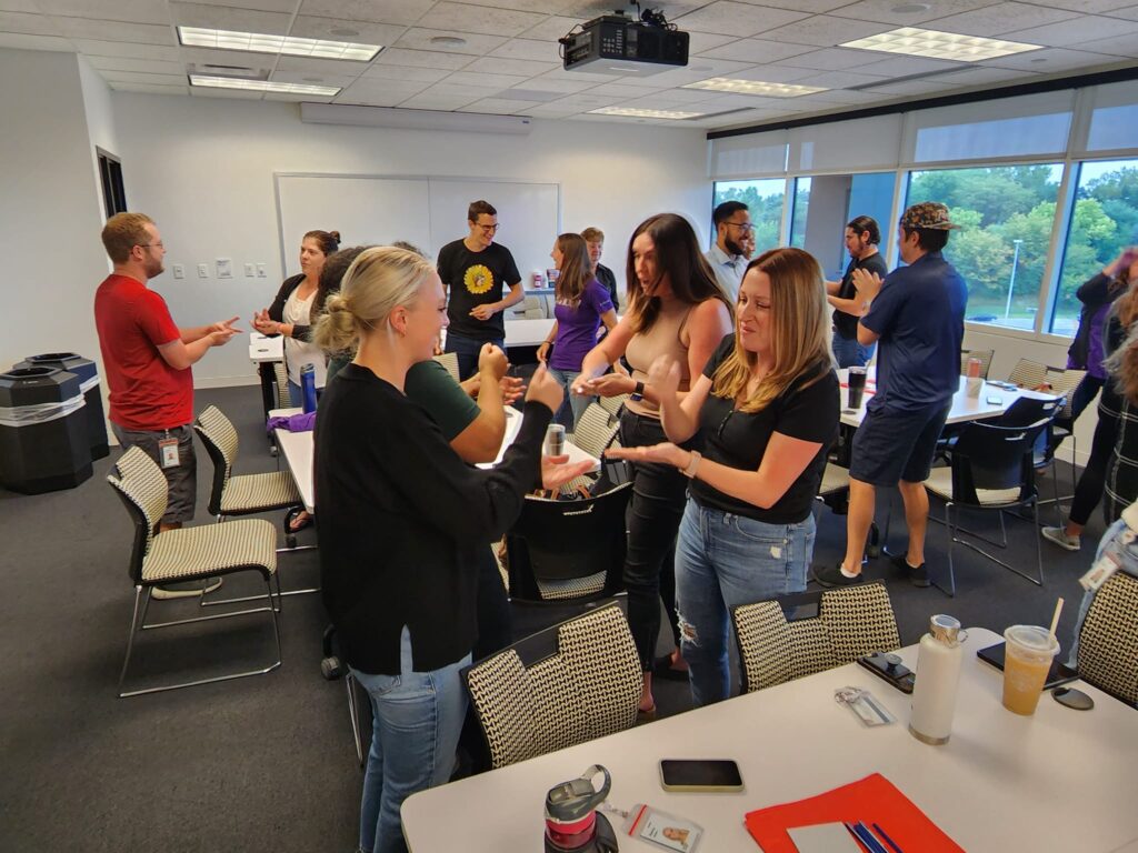 Team members engaged in an interactive Hopefull Handbags Global team building event, preparing essential care items to be packed into handbags for domestic abuse survivors.