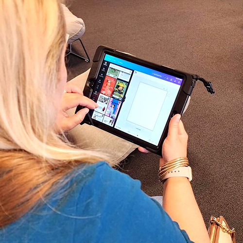 Participant designs creative elements for a charity team building event using a tablet during the Hopefull Handbags Global program.