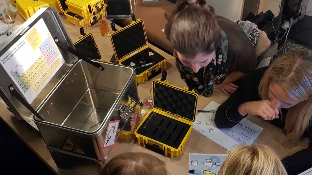 Team working together on a puzzle during the 'Atmosphere' team building event, analyzing clues and tools from a case to solve challenges and unlock the next phase.