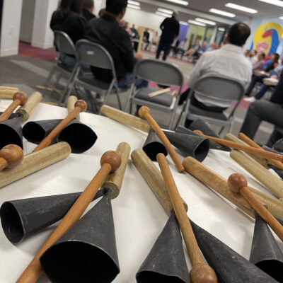 Close-up of cowbells and drumsticks on a table, ready for use in a BeatsWork team building drumming session.