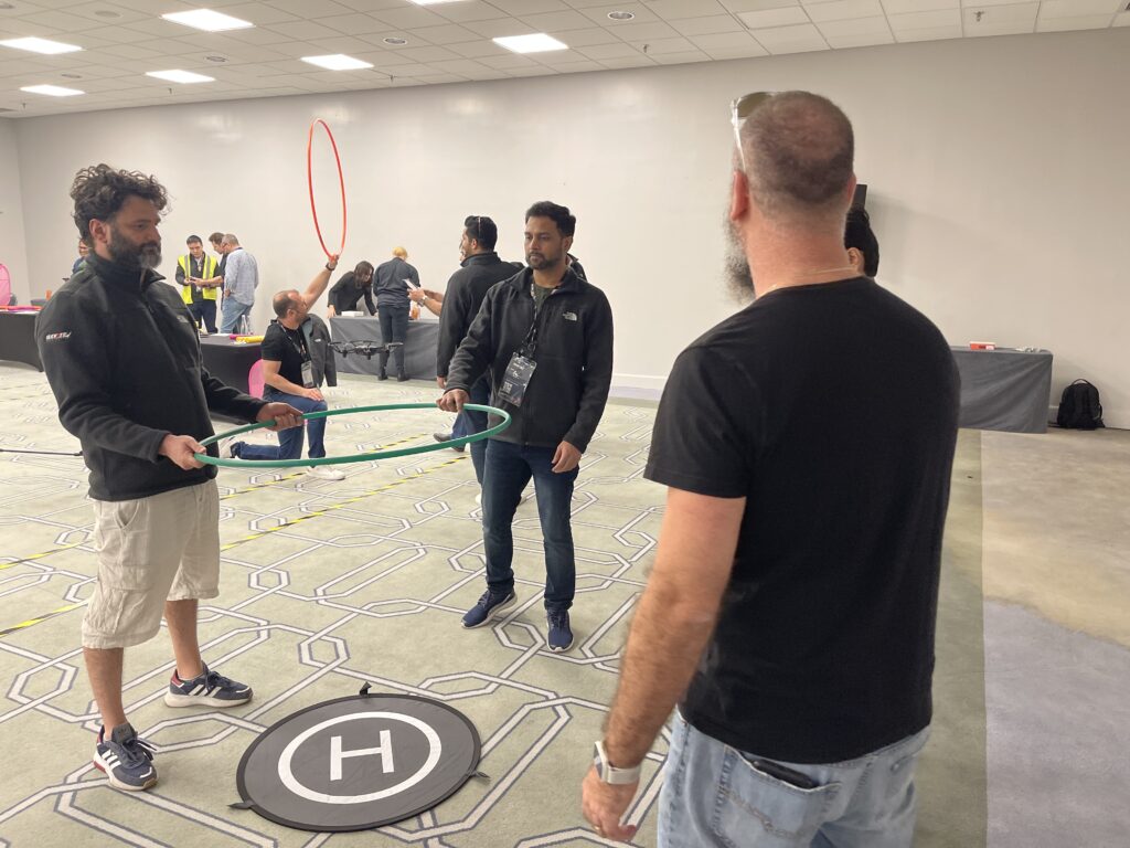 Team members strategize their next move while guiding a drone through an obstacle course during the Game of Drones team building event.